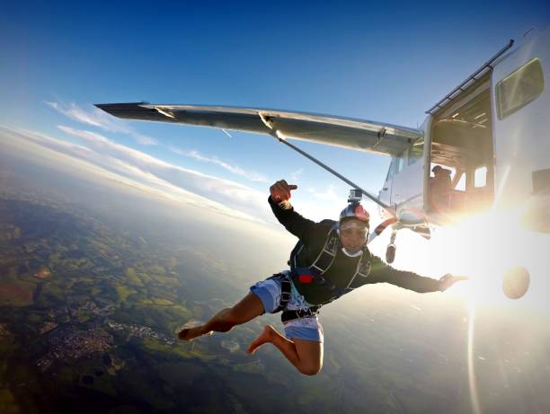 istock Barefoot man jumping from parachute at sunset. 1022904512