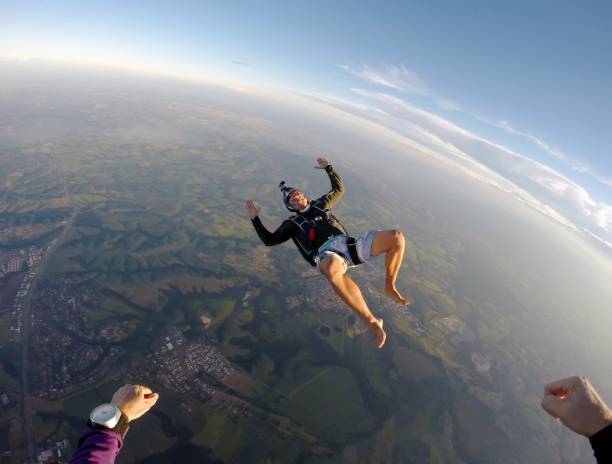istock Barefoot man jumping from parachute at sunset. 1022904518
