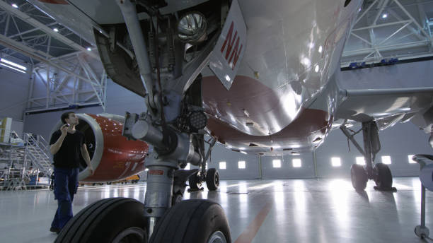 istock In a Hangar Aircraft Maintenance Engineer/ Technician/ Mechanic Visually Inspects Airplane's Chassis and Body/Fuselage walking Under It. 1022905166