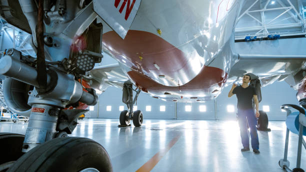 istock In a Hangar Aircraft Maintenance Engineer/ Technician/ Mechanic Visually Inspects Airplane's Chassis and Body/Fuselage walking Under It. 1022905180