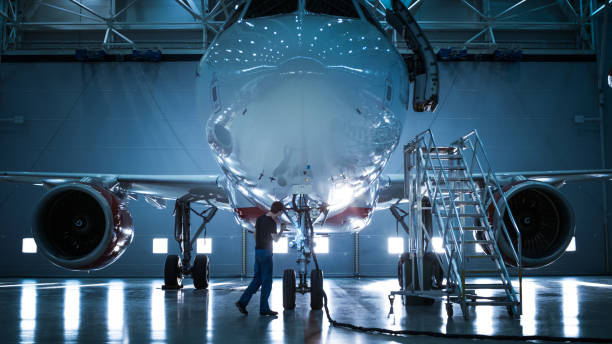 nuevo pie de avión en un hangar de mantenimiento de aeronaves al ingeniero de mantenimiento de aeronaves de la marca / técnico / mecánico va dentro de cabina a través de escalera / rampa. - hangar fotografías e imágenes de stock