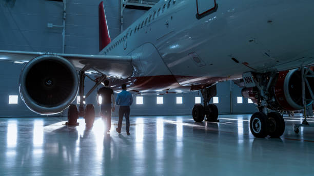 istock In a Hangar Aircraft Maintenance Engineer Shows  Technical Data on Tablet Computer to Airplane Technician. They Walk Alongside Clean Brand New Plane. 1022905232