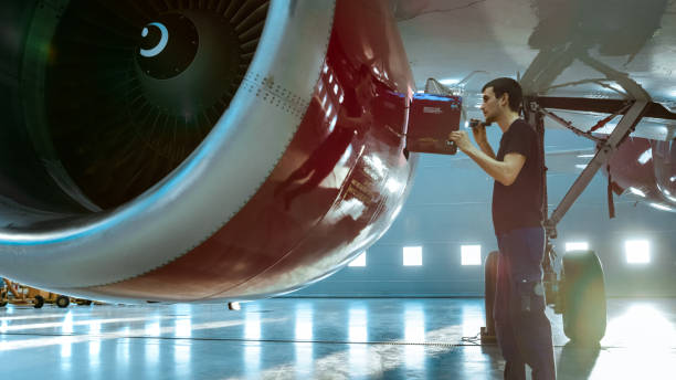 istock In a Hangar Aircraft Maintenance Young Engineer/ Technician/ Mechanic With Tablet Computer Inspects Airplane Jet Engine. He Opens Engine Hatch and Examines Insides with a Flashlight. 1022905250
