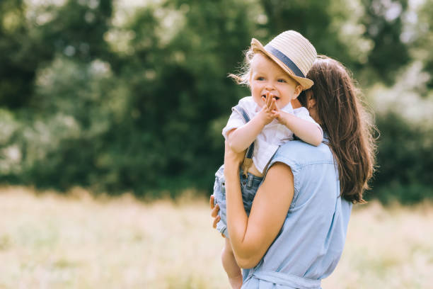 istock mother holding son on hands and walking in field 1022910730