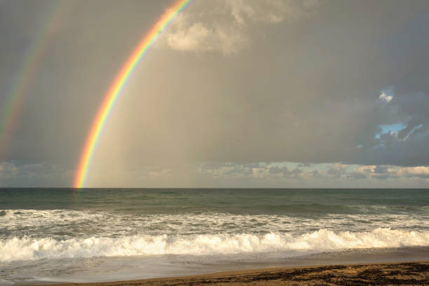 istock Rainbow over the sea and tropical beach. Top view. 1022911920