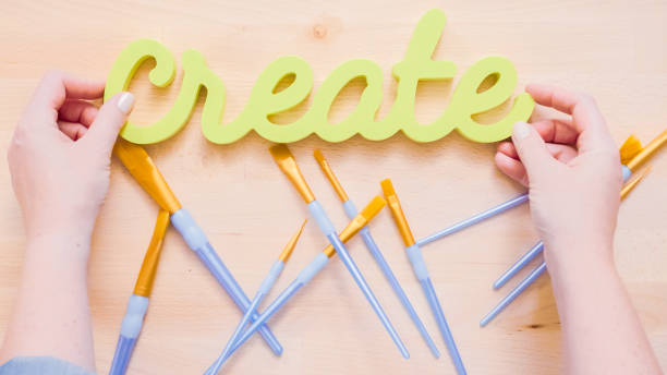 Green create sign with paint brushes on the table.