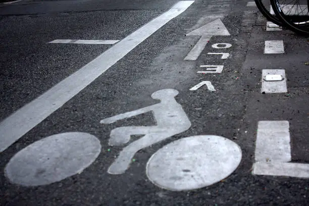 Floor marking bicycle pictogram. Visible parked bicycle wheels