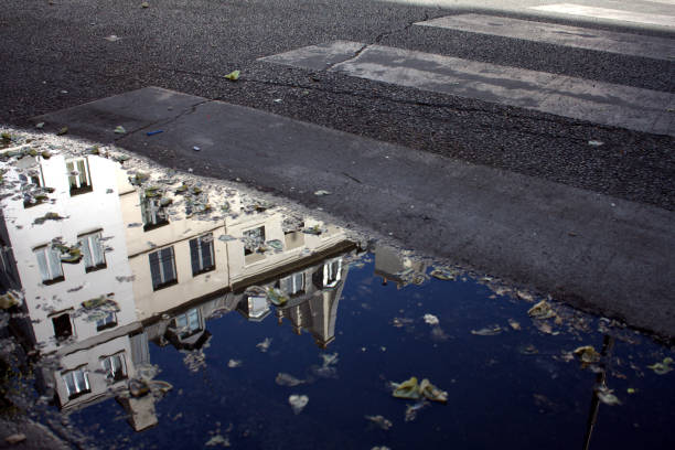 istock PUDDLE WATER REFLECTING BUILDING ON PASSAGE PIETON PARISIAN 1022924606