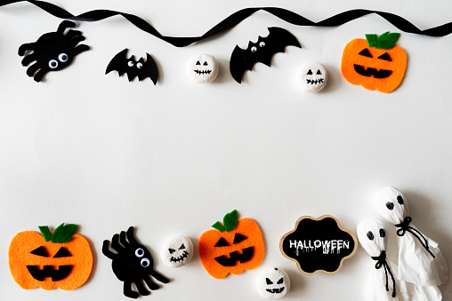 Top view of Halloween crafts, orange pumpkin, ghost and spide on white background with copy space for text. halloween concept.