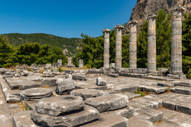 riene, ancient city of Ionia about 6 miles (10 km) north of the Menderes (Maeander) River and 10 miles (16 km) inland from the Aegean Sea, in southwestern Turkey. Its well-preserved remains are a major source of information about ancient Greek town planning.
By the 8th century BC Priene was a member of the Ionian League, whose central shrine, the Panionion, lay within the city’s territory. Priene was sacked by Ardys of Lydia in the 7th century BC but regained its prosperity in the 8th. Captured by the generals of the Persian king Cyrus (c. 540), the city took part in several revolts against the Persians (499–494). Priene originally lay along the Maeander River’s mouth, but about 350 BC the citizens built a new city farther inland, on the present site. The new city’s main temple, of Athena Polias, was dedicated by Alexander the Great in 334. The little city grew slowly over the next two centuries and led a quiet existence; it prospered under the Romans and Byzantines but gradually declined, and after passing into Turkish hands in the 13th century AD, it was abandoned. Excavations of the site, which is occupied by the modern town of Samsun Kale, began in the 19th century.
Modern excavations have revealed one of the most beautiful examples of Greek town planning. The city’s remains lie on successive terraces that rise from a plain to a steep hill upon which stands the Temple of Athena Polias. Built by Pythius, probable architect of the Mausoleum of Halicarnassus, the temple was recognized in ancient times as the classic example of the pure Ionic style. Priene is laid out on a grid plan, with 6 main streets running east-west and 15 streets crossing at right angles, all being evenly spaced. The town was thereby divided into about 80 blocks, or insulae, each averaging 150 by 110 feet (46 by 34 m). About 50 insulae are devoted to private houses; the better-class insulae had four houses apiece, but most were far more subdivided. aydin - turquía. 03 de junio, ruinas de la antigua ciudad de priene. soke, aydin - turkey.priene es una antigua ciudad helenística situada justo al norte de mileto en turquía occidental. fue una antigua ciudad griega de santo y el inicio de un importan