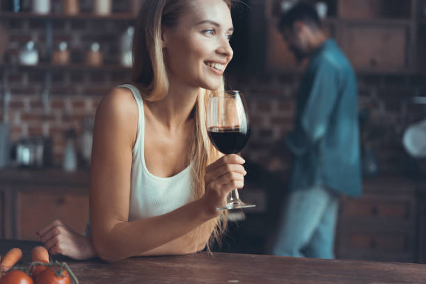 istock Pretty woman drinking some wine at home in kitchen . 1022937632