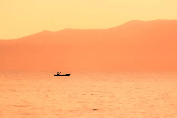kayak sailing in the coast at sunset