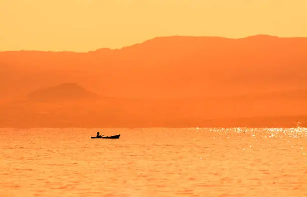 kayak sailing in the coast at sunset