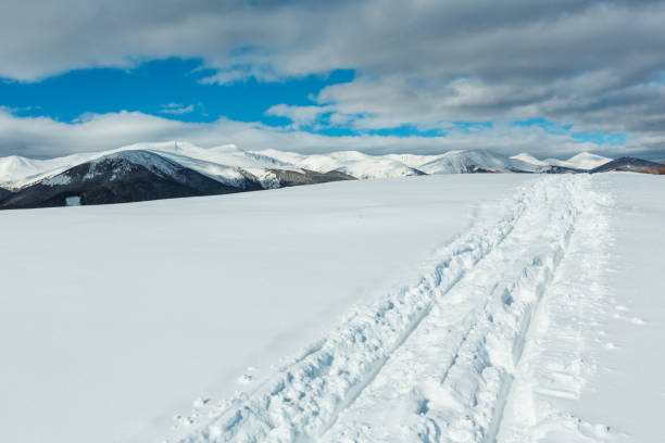 istock Sledge trace and footprints on winter mountain hill top 1022975422