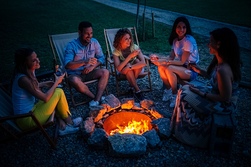 Friends having fun around the campfire at night.