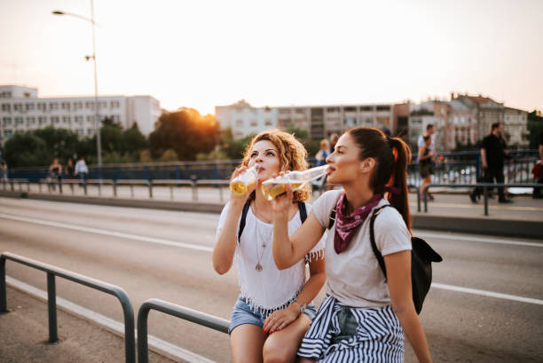 istock Party girls drinking while sitting on the bridge. 1022991904