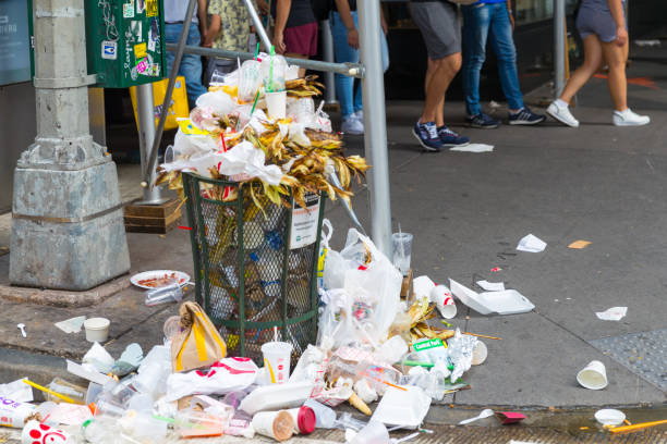 An overflowing trash can on the streets of Manhattan New York stock photo