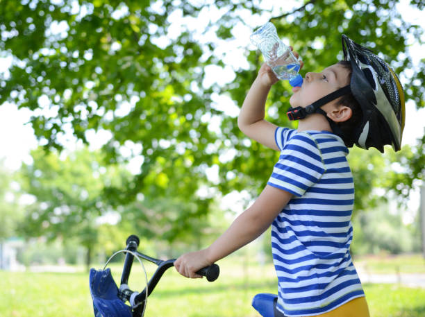 istock Boy resting after ride and drinking water 1023015912