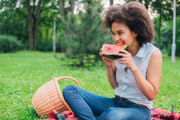 istock Smiling woman eating watermelon on a picnic 1023025736