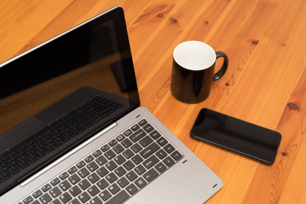 istock Wooden office desk table with laptop, cup and smartphone. Top view. 1023035344