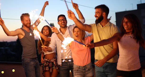 istock Friends enjoying rooftop party with sparklers 1023035564