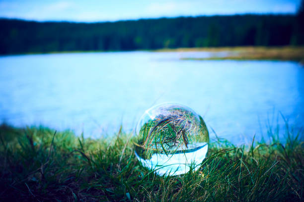 Glass ball display lake and forrest. The concept of environment, nature protection, ecology. Selective focus
