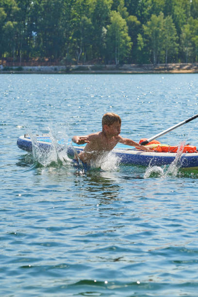 istock Paddle boarder. Child boy paddling on stand up paddleboard 1023041702