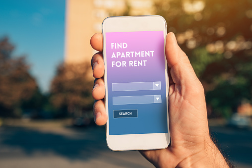 Apartment renting app on smartphone mock up screen in male hand