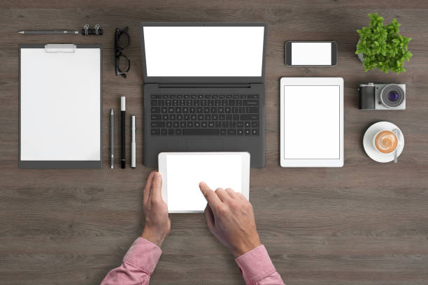 istock Man holding tablet knolling overhead view 1023042498