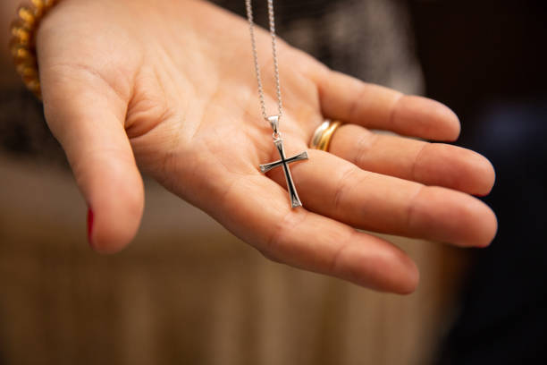 bautizos ortodoxos de un niño, una cruz en la mano de su padre - necklace fotografías e imágenes de stock