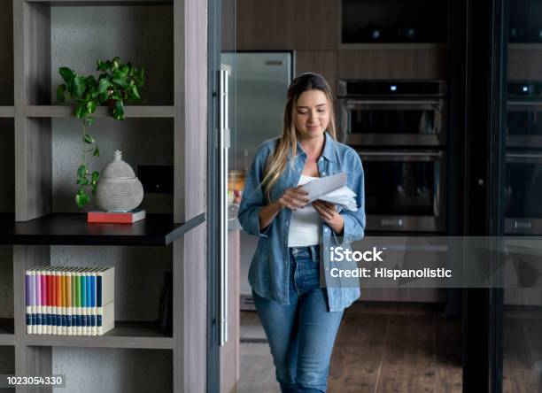 Beautiful Woman Walking At Her Apartment While Opening Letters Stock Photo - Download Image Now