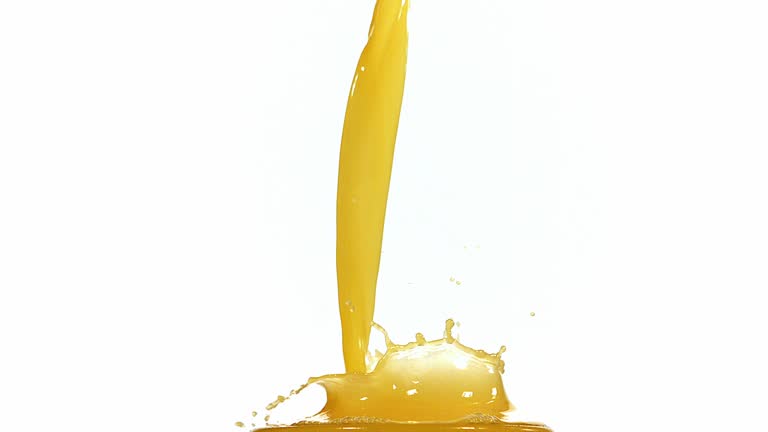 Orange Juice being poured into Glass against White Background, Slow Motion