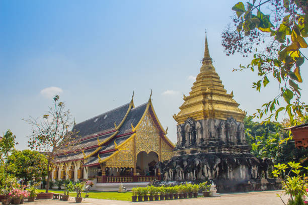 bella chiesa e chedi dorati in stile lanna sostenuti da file di contrafforti a forma di elefante a wat chiang man, il tempio più antico di chiang mai, in thailandia, costruito nel 1296 dal re mengrai del regno di lanna. - wat chiang man foto e immagini stock