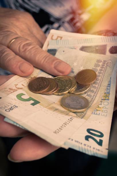 istock older woman's hand with cash, savings and pensions 1023066742