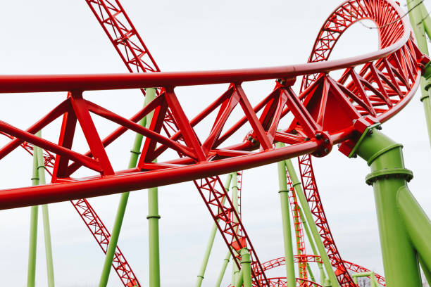 a colorful looping roller coaster in the park - ferris wheel fotos imagens e fotografias de stock