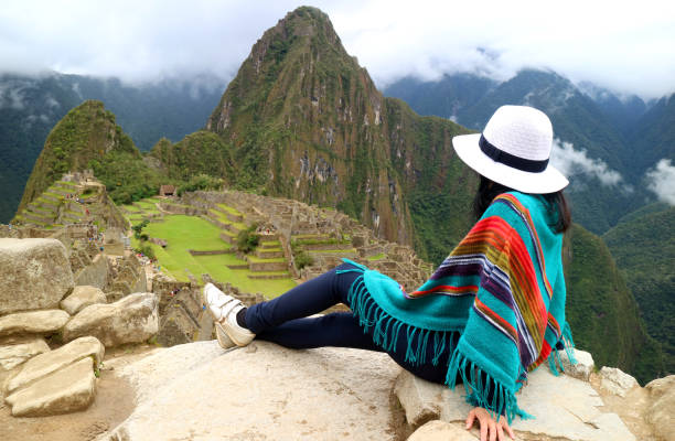 Young female traveler admiring the Inca ruins of Machu Picchu, one of the New Seven Wonder of The World, Cusco Region, Urubamba Province, Peru Young female traveler admiring the Inca ruins of Machu Picchu, one of the New Seven Wonder of The World, Cusco Region, Urubamba Province, Peru urubamba province stock pictures, royalty-free photos & images