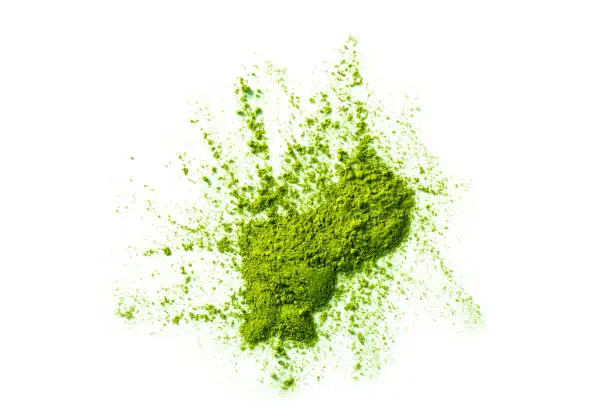 green matcha tea powder ground in erratic form isolated on white background