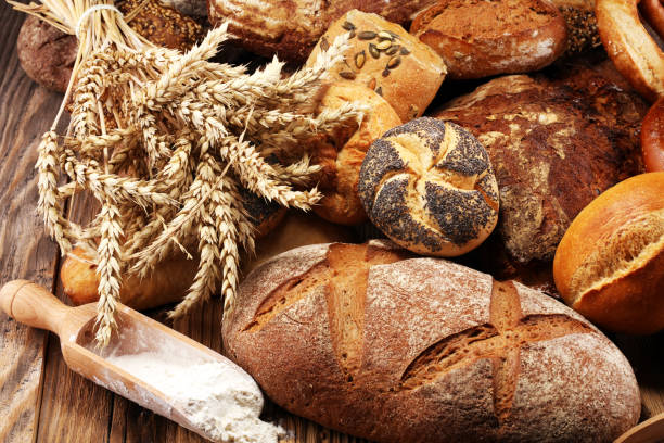 istock Different kinds of bread and bread rolls on board from above. Kitchen or bakery 1023070570