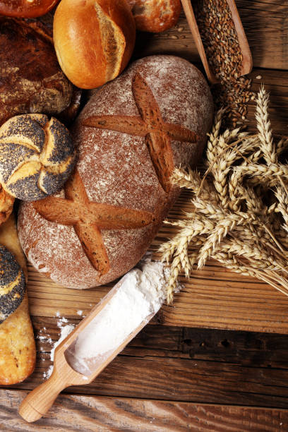 istock Different kinds of bread and bread rolls on board from above. Kitchen or bakery 1023070802