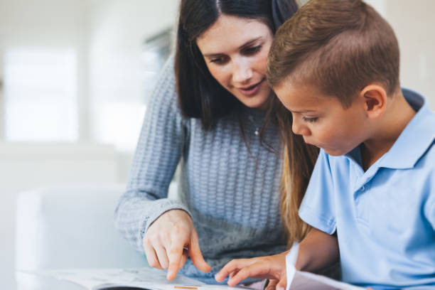 boy getting tutored with school assignment stock photo