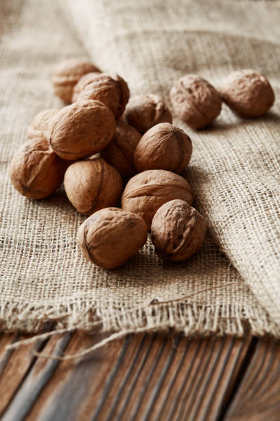 istock Walnuts and kernels with burlap fabric on a dark rusty wood backdrop 1023091058