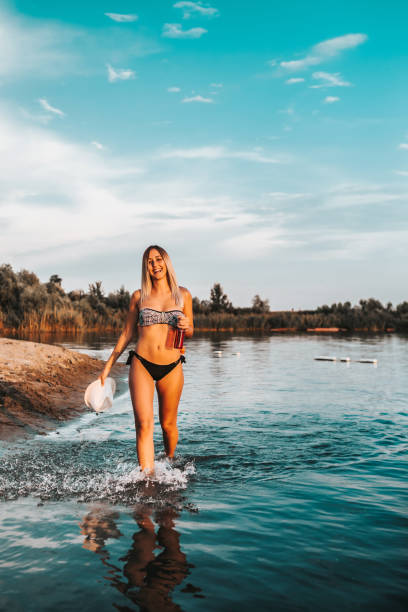 istock Girl in swimsuit having fun while walking in lake 1023108176