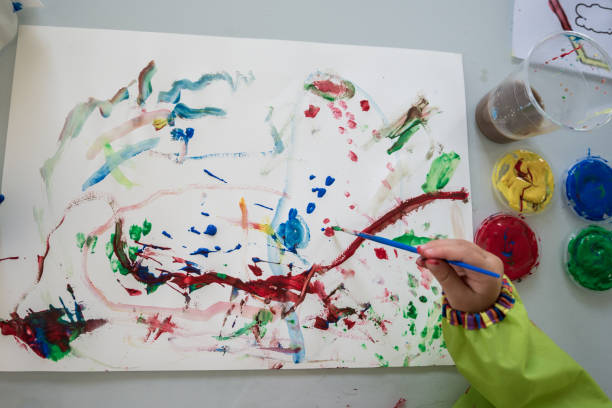 istock Young child creating a colourful abstract painting 1023109182