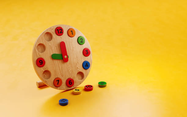 Educational wooden toy clock on yellow background. Horizontal composition with copy space.