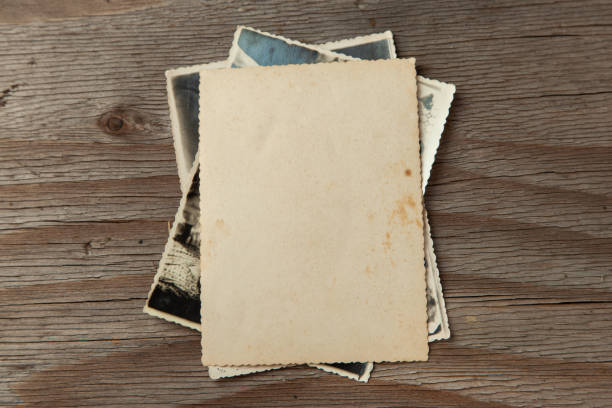 istock Stack old photos on table. Mock-up blank paper. Postcard rumpled and dirty vintage 1023114746