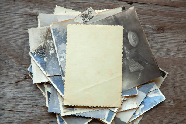 istock Stack old photos on table. Mock-up blank paper. Postcard rumpled and dirty vintage 1023114960