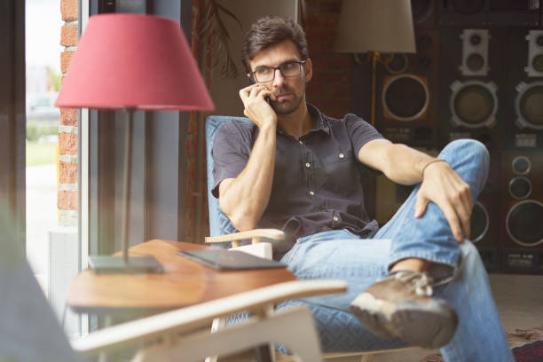 istock Young entrepreneur working on startup in modern office using digital tablet. Man wearing glasses and jeans, serious face. 1023115404