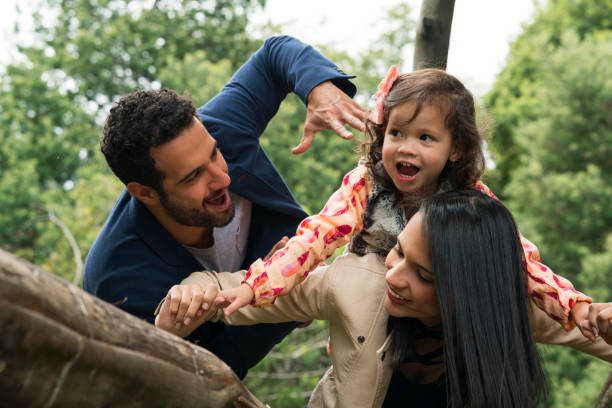 Family playing in the park Family latin, parents between 25 and 30 years old and a small girl between 3 and 5 years old, happily playing the little plane in the park, all smile niñas stock pictures, royalty-free photos & images