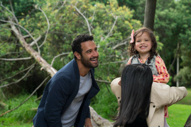 Family playing in the park Family latin, parents between 25 and 30 years old and a small girl between 3 and 5 years old, happily playing the little plane in the park, all smile niñas stock pictures, royalty-free photos & images