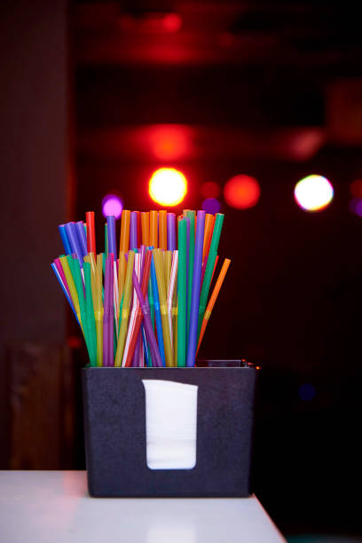 istock A bunch of bright multicolored straws on a dark background with a bokeh. 1023128078